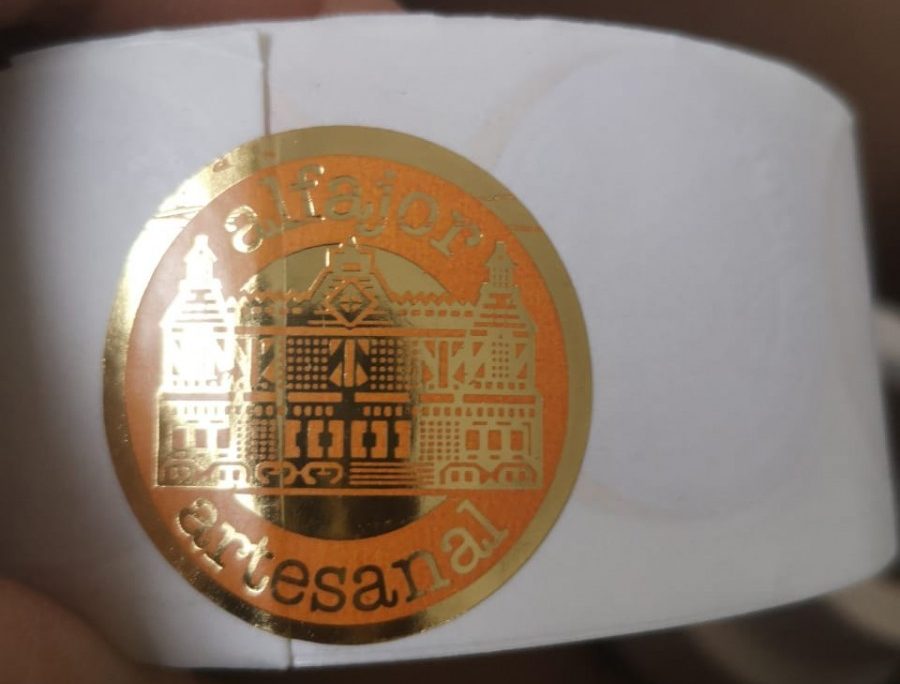 Rollo Sticker Alfajor Castillo Artesanal dorado con fondo naranjo